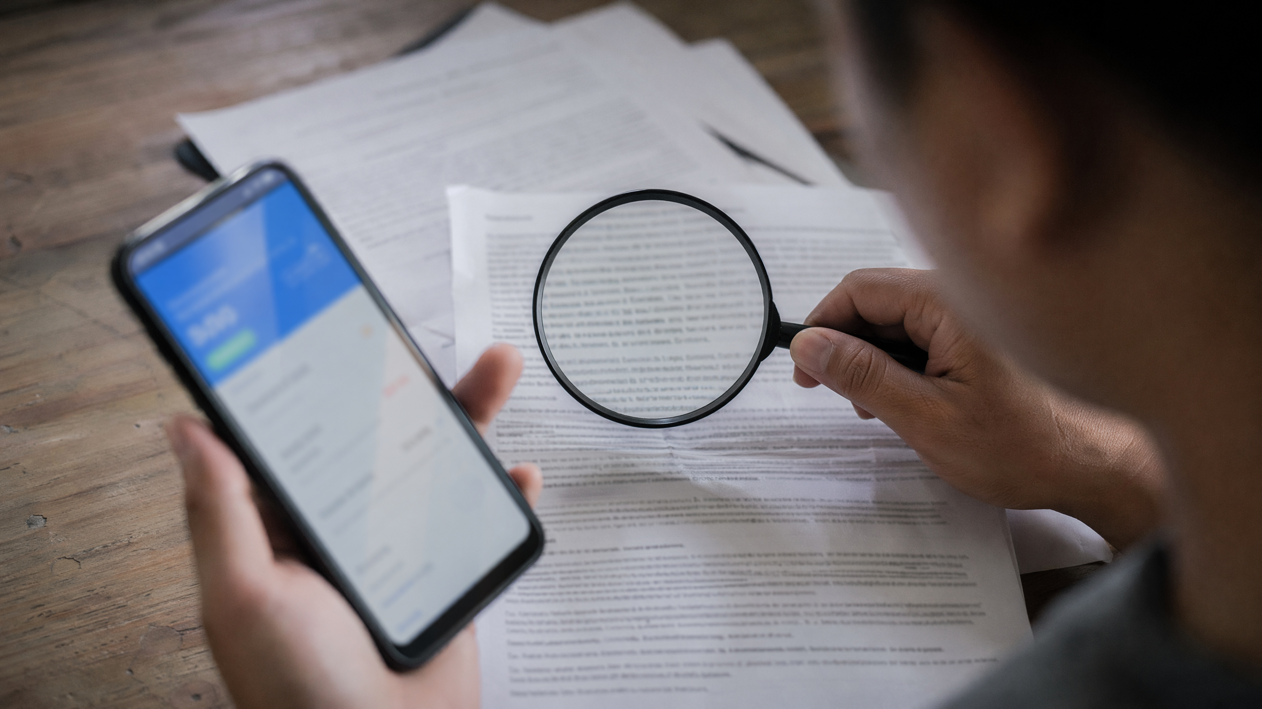 Smartphone con app de remesas, letra pequeña