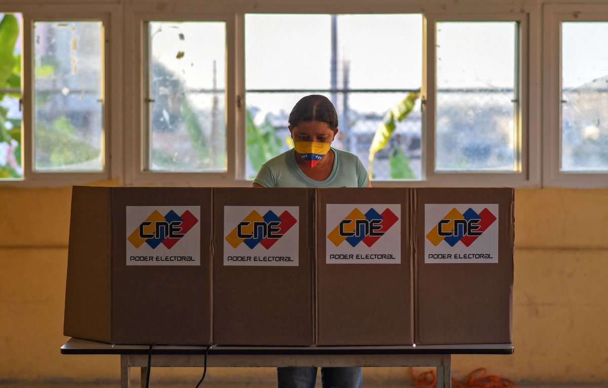 Mesa electoral venezolana con urnas CNE