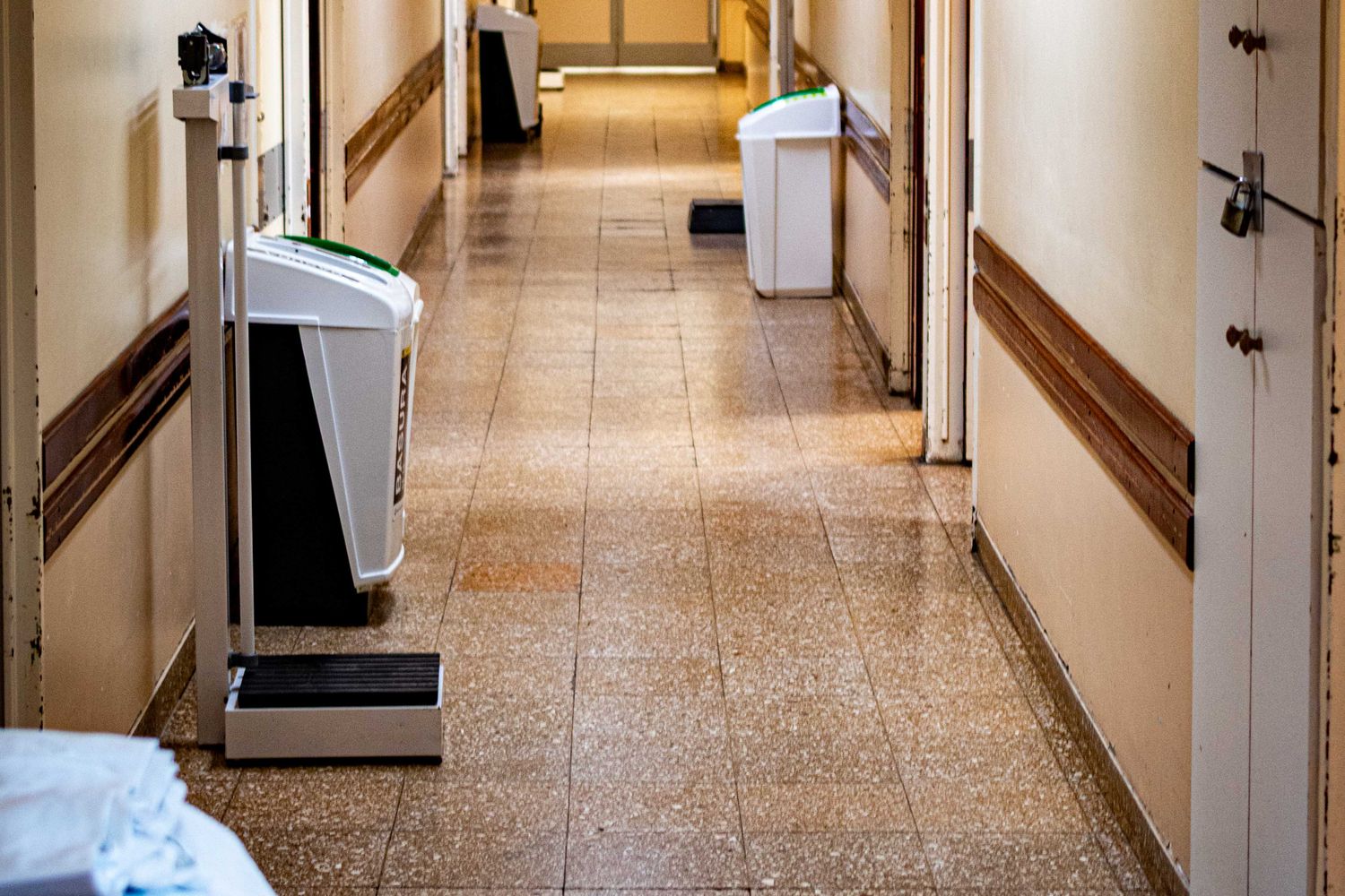 Pasillo institucional vacío, sin menores identificables.