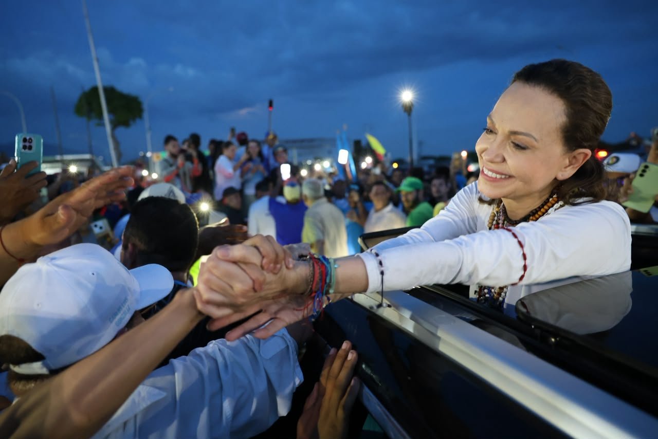 María Corina Machado saluda a personas que la reciben durante el recorrido hacia Caracas